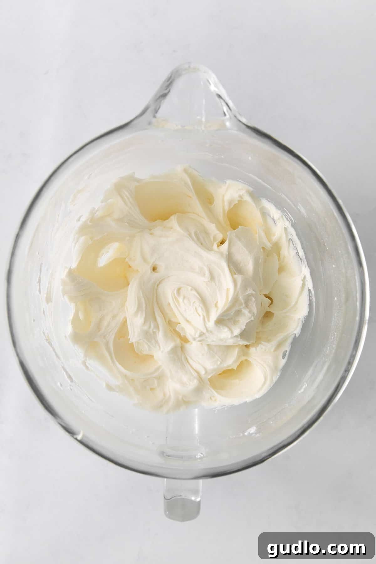 Velvety Vanilla Cream Cheese Frosting 5 A bowl of freshly whipped cream cheese frosting, ready for decorating, with a smooth and fluffy texture.