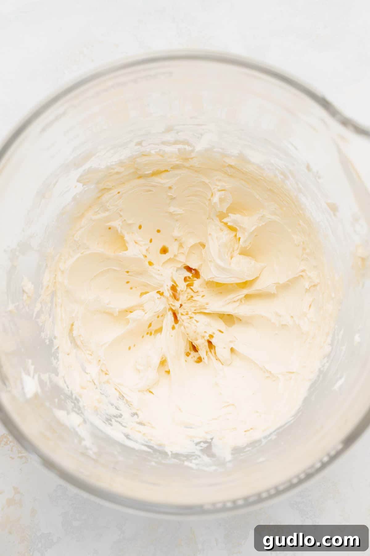 Luxurious cream cheese frosting elegantly swirled in a pristine bowl, perfectly ready for application on cakes or cupcakes.