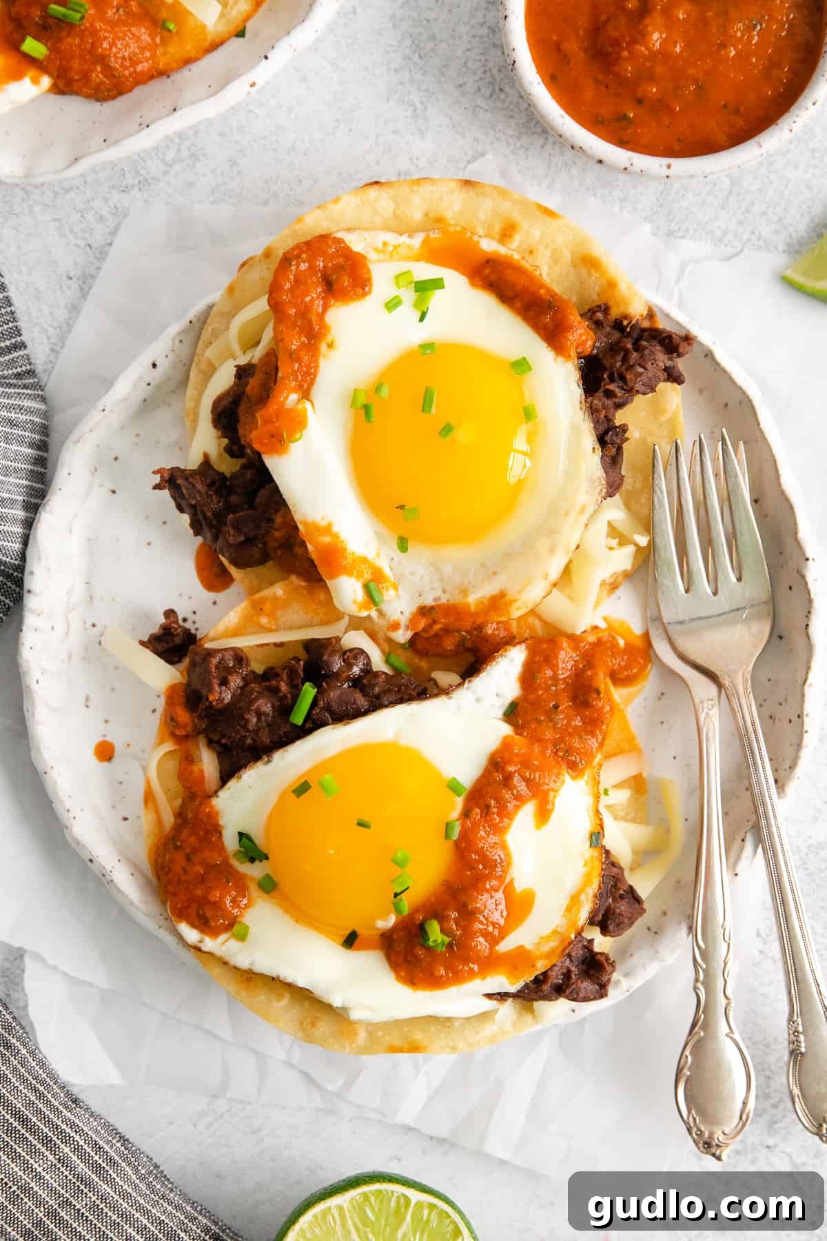 Southwest Breakfast Classic 2 A plate of vibrant homemade huevos rancheros with a runny fried egg, black beans, and rich red sauce on a corn tortilla.