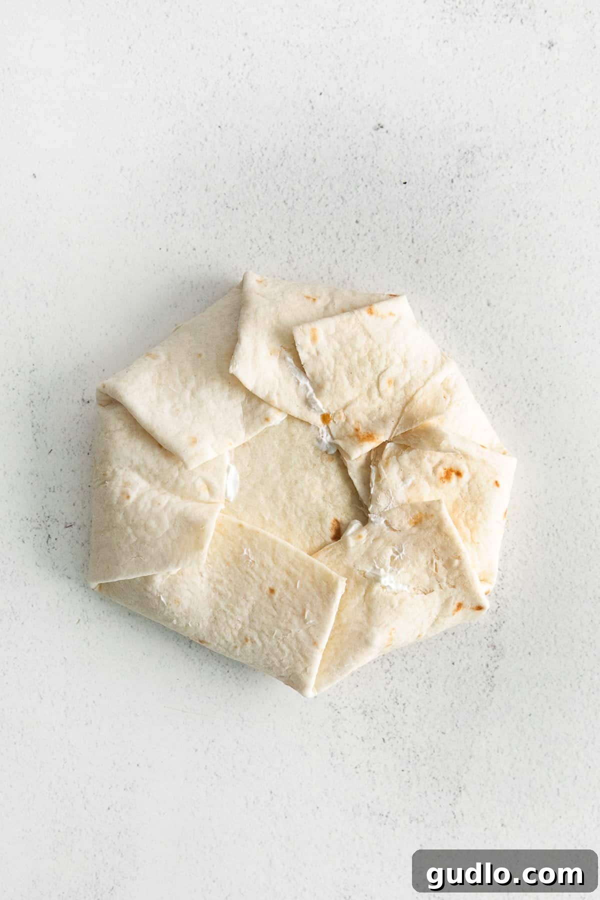 Perfectly Folded: The Crunchwrap's Final Form A neatly folded crunchwrap supreme, ready for searing in the skillet.