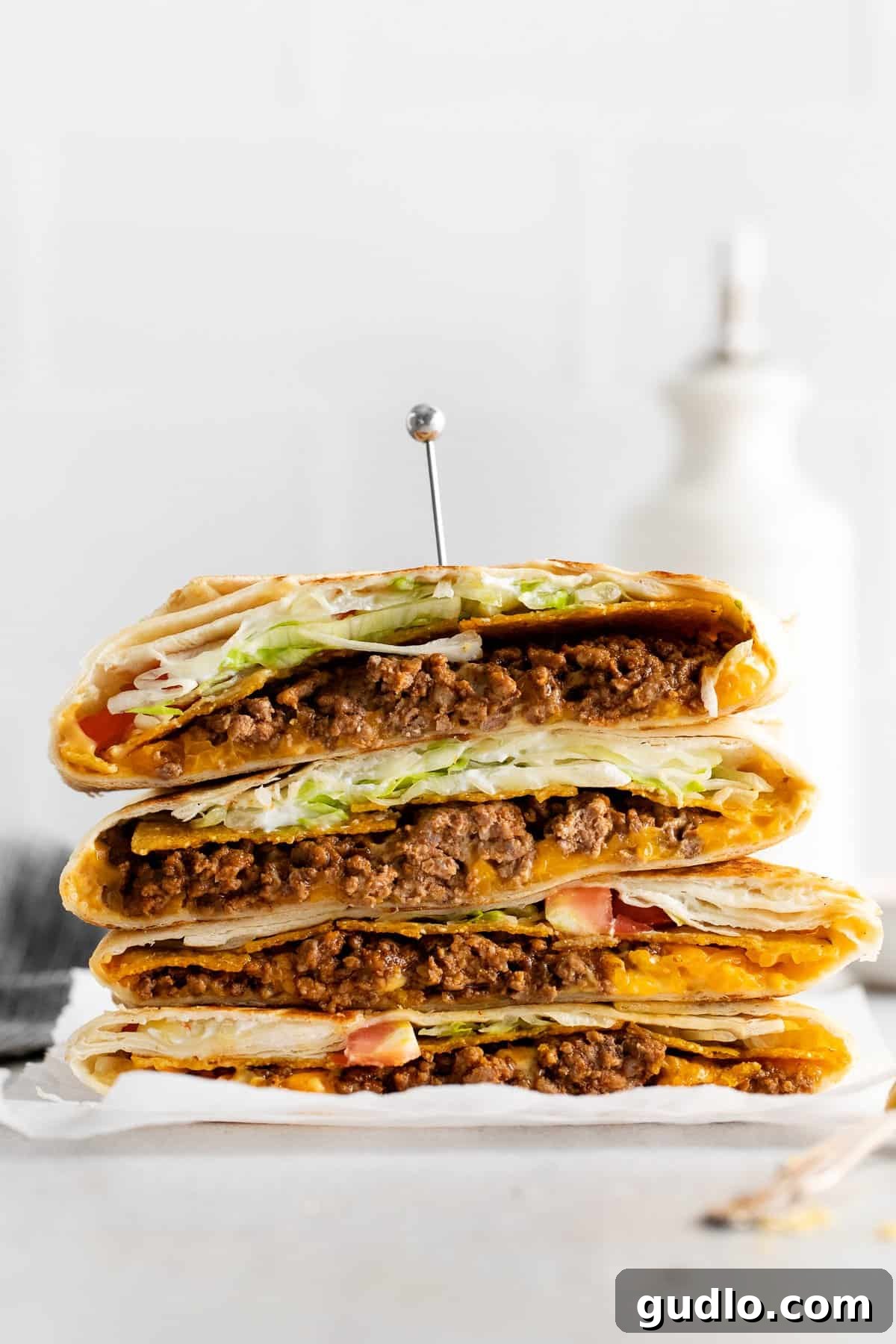 Stacked High: Delicious Crunchwraps for Everyone Multiple crunchwrap supremes stacked neatly on a plate, ready to be served.