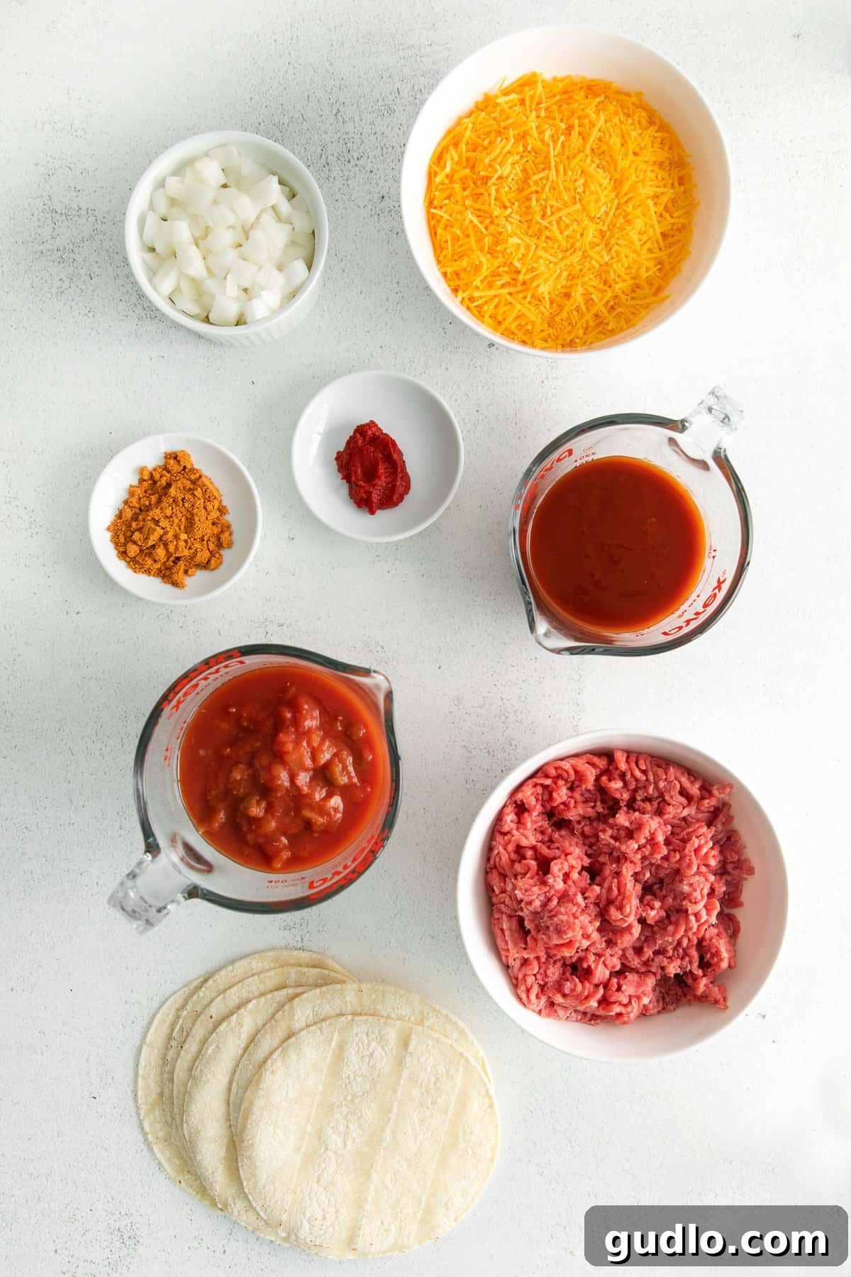 Cheesy Taco Bake 3 Ingredients for beef taco bake laid out in bowls on a counter.