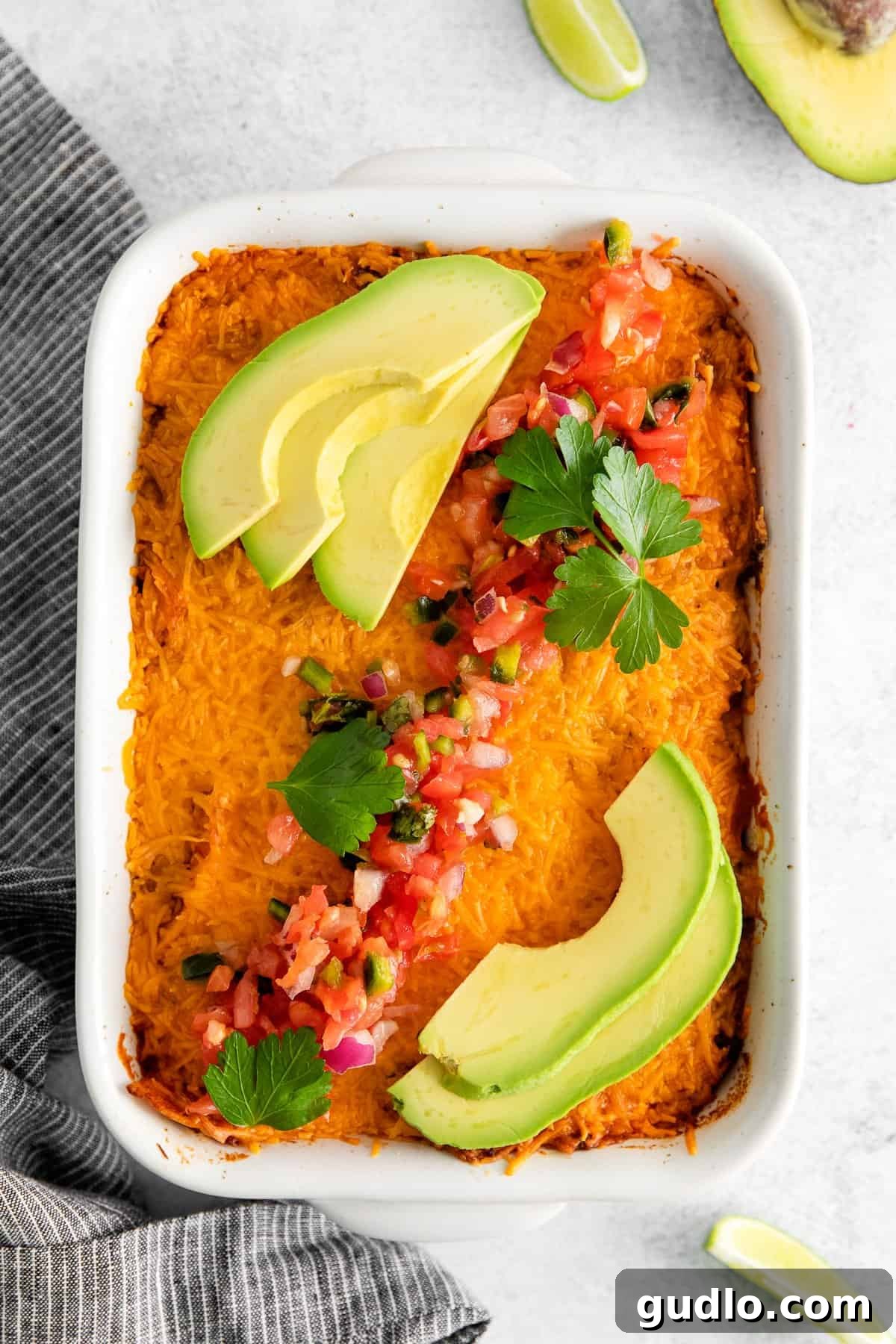 Cheesy Taco Bake 9 Finished taco bake garnished with fresh avocado slices and pico de gallo, ready to be served.