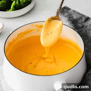 Steamed broccoli florets generously coated in a rich, creamy cheese sauce, served as a tempting side dish, highlighting the perfect pairing.
