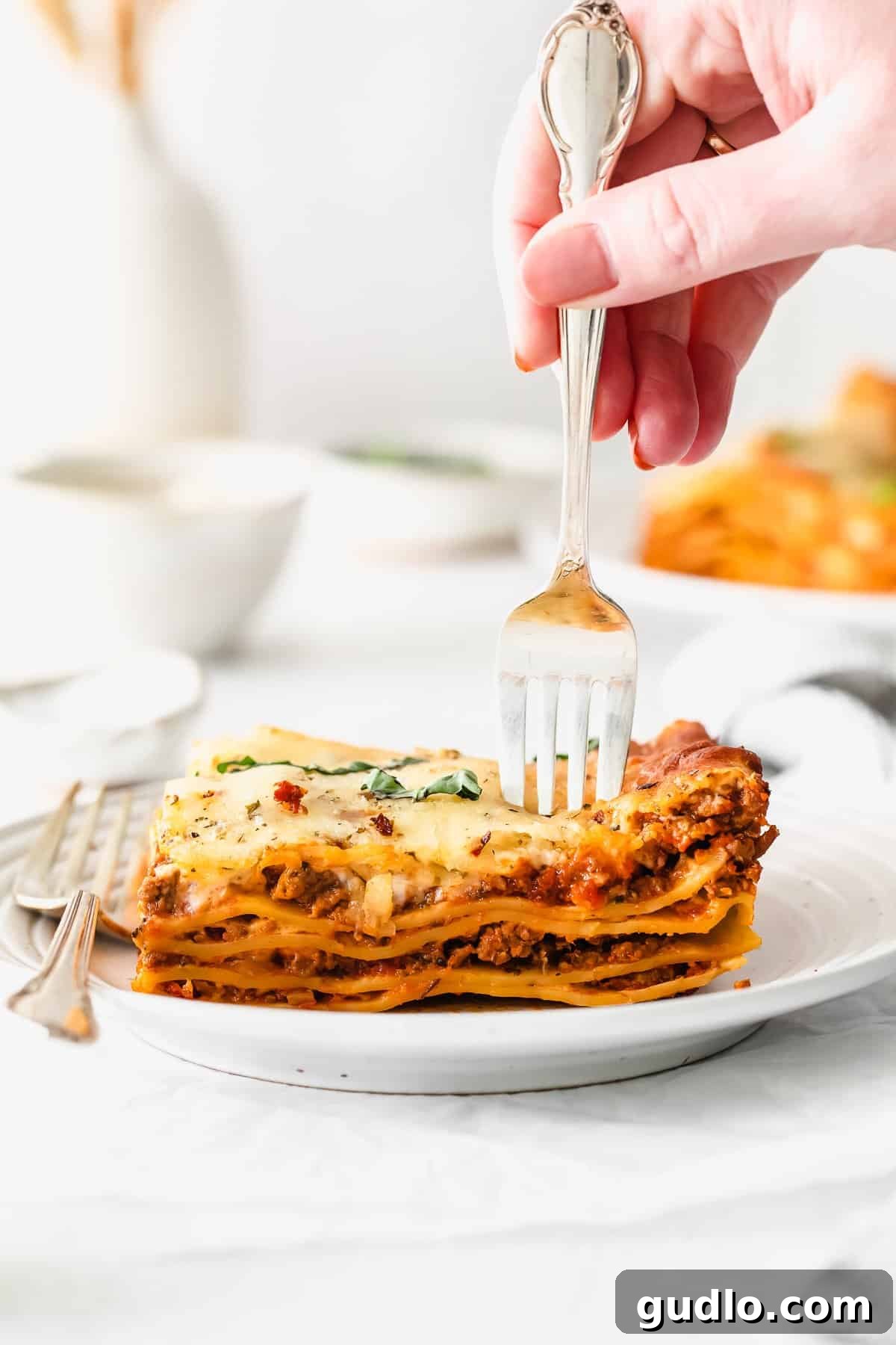 Close-Up of Bechamel Lasagna Slice A delectable slice of bechamel lasagna on a fork, showing the creamy layers and rich meat sauce.