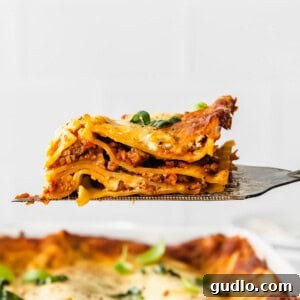 Perfecting Bechamel: The Mother Sauce 2 A delicious slice of Bechamel Lasagna being lifted on a fork, showing off its creamy layers.