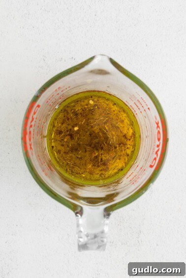 Warm olive oil with onion and garlic in a measuring cup.