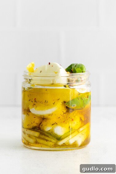 Marinated goat cheese in a jar, infusing flavors.