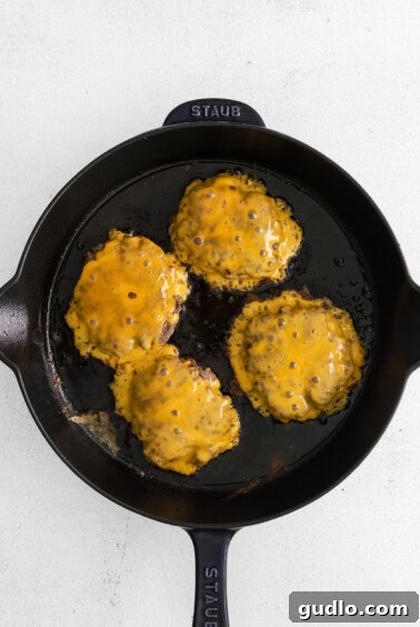 Easy Homemade Cheeseburgers 6 Cheeseburgers with melting cheese in a skillet.
