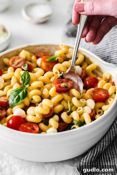 Caprese Pasta salad with creamy dressing freshly poured on top.