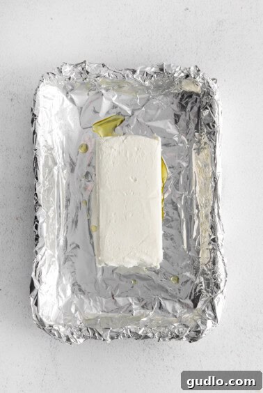 A block of cream cheese in an aluminum foil boat.