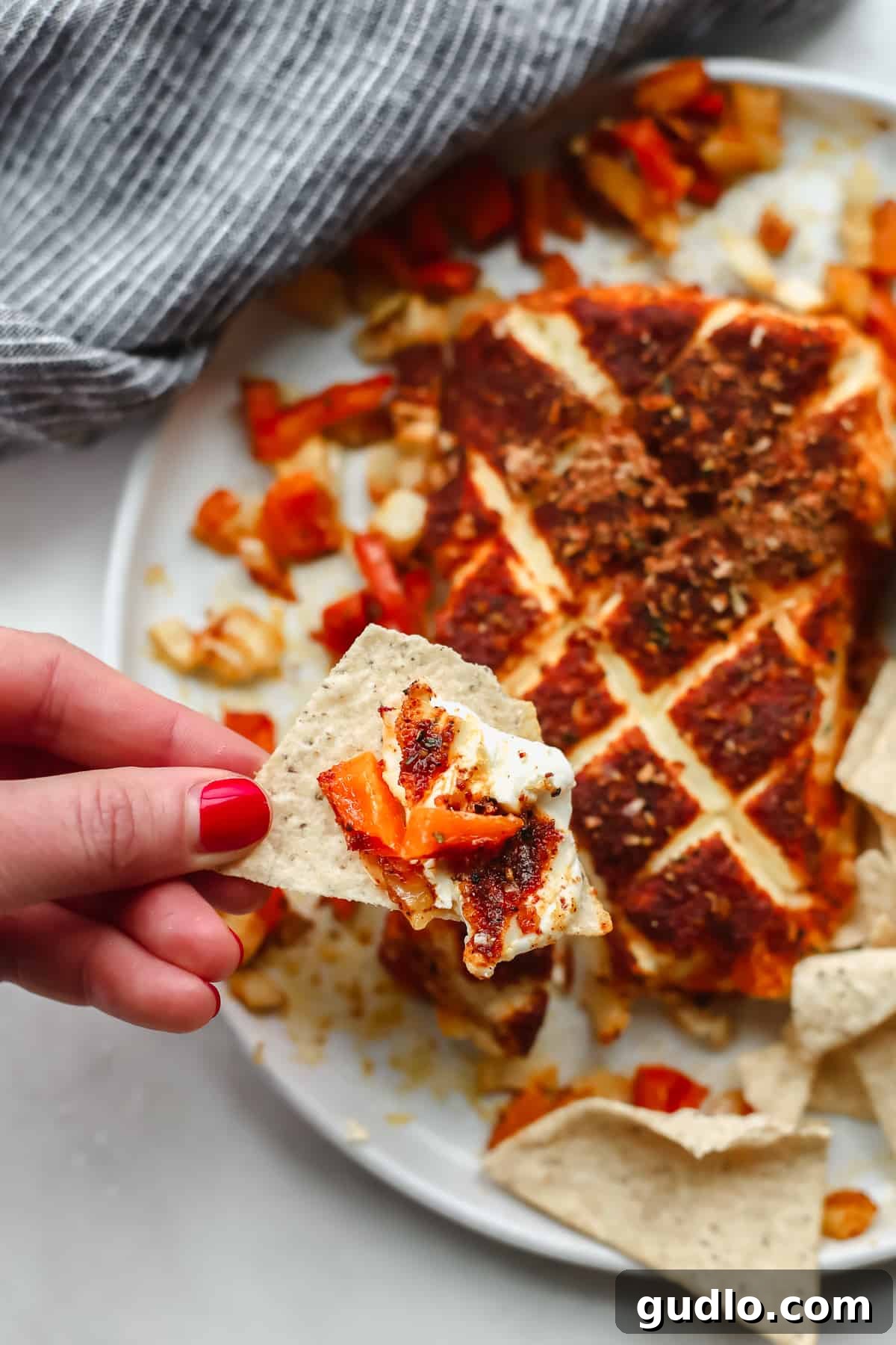 Savor the rich and smoky taste of cream cheese on a crunchy tortilla chip – a perfect pairing. A delicious scoop of perfectly smoked cream cheese, generously perched on a crisp tortilla chip, elegantly presented and ready for a savory bite.