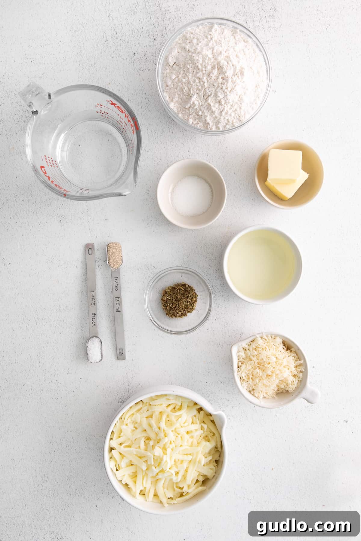 Fresh Ingredients for Homemade Cheese Bread Bowls filled with fresh ingredients for cheese bread, including flour, yeast, butter, and cheeses.