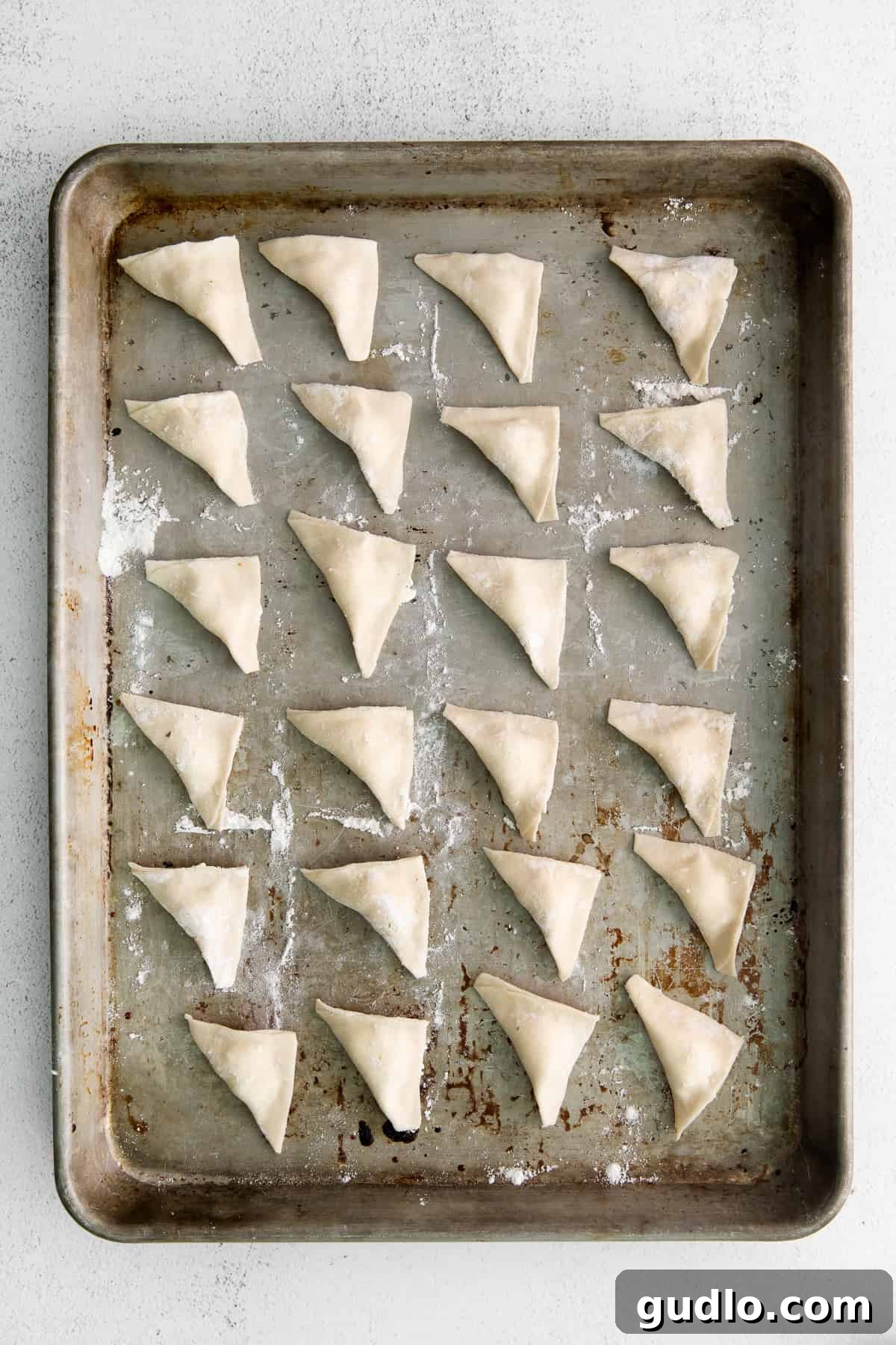 A pasta square with a dollop of cheese filling in the center, illustrating the next step.