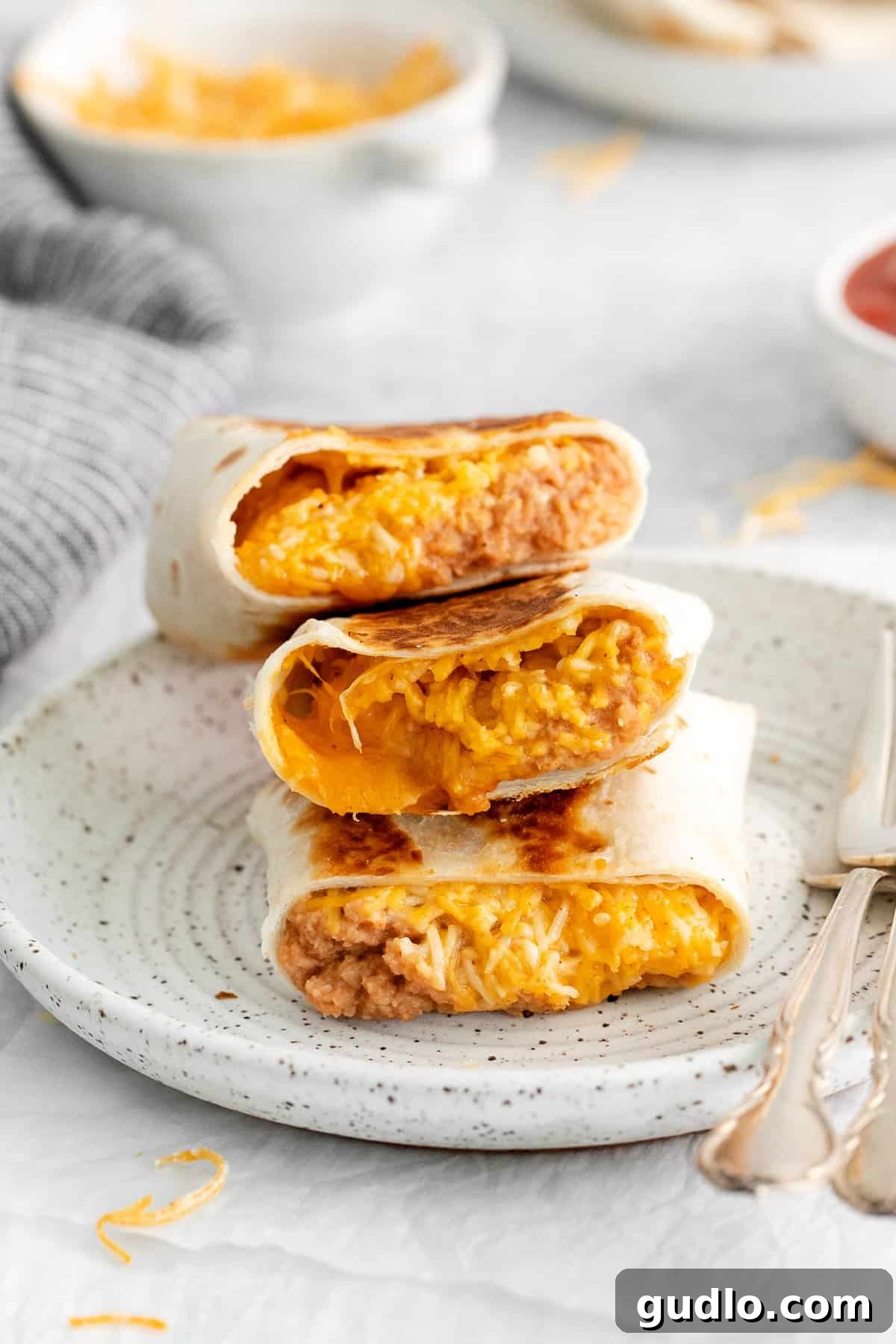 Easy Bean and Cheese Burrito Recipe for Lunch and Meal Prep A perfectly rolled bean and cheese burrito, golden-brown and ready to eat, served on a plate.