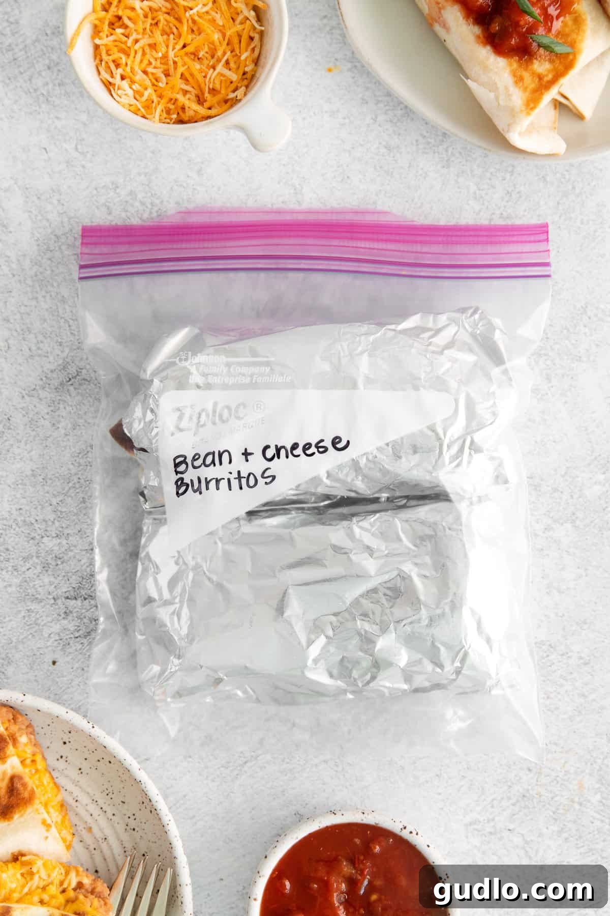 Freezer-Ready Bean and Cheese Burritos for Meal Prep Several foil-wrapped bean and cheese burritos neatly stacked in a clear freezer bag, labeled for meal prep.
