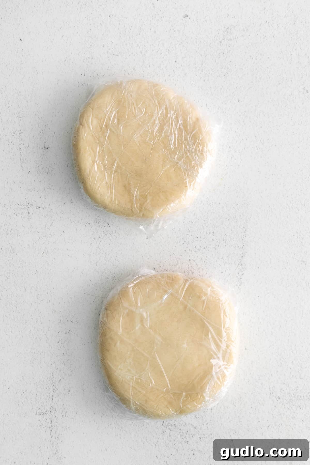 Chilling Cracker Dough Cracker dough wrapped tightly in plastic wrap, chilling in the refrigerator, highlighting the importance of proper dough preparation.