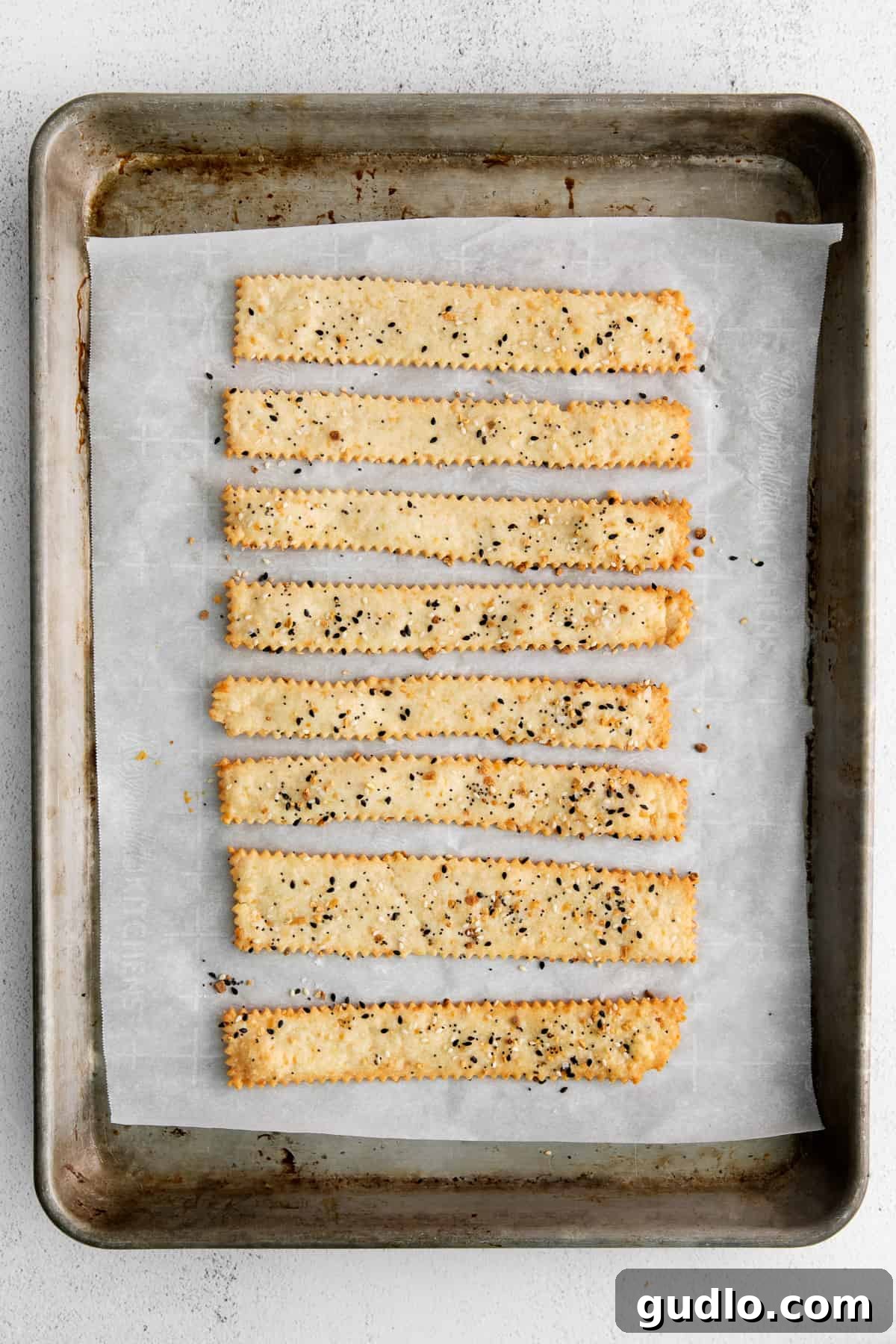 Baked Cheese Crackers A close-up of beautifully golden, crunchy homemade cheese crackers on a baking sheet, fresh out of the oven and ready for serving.