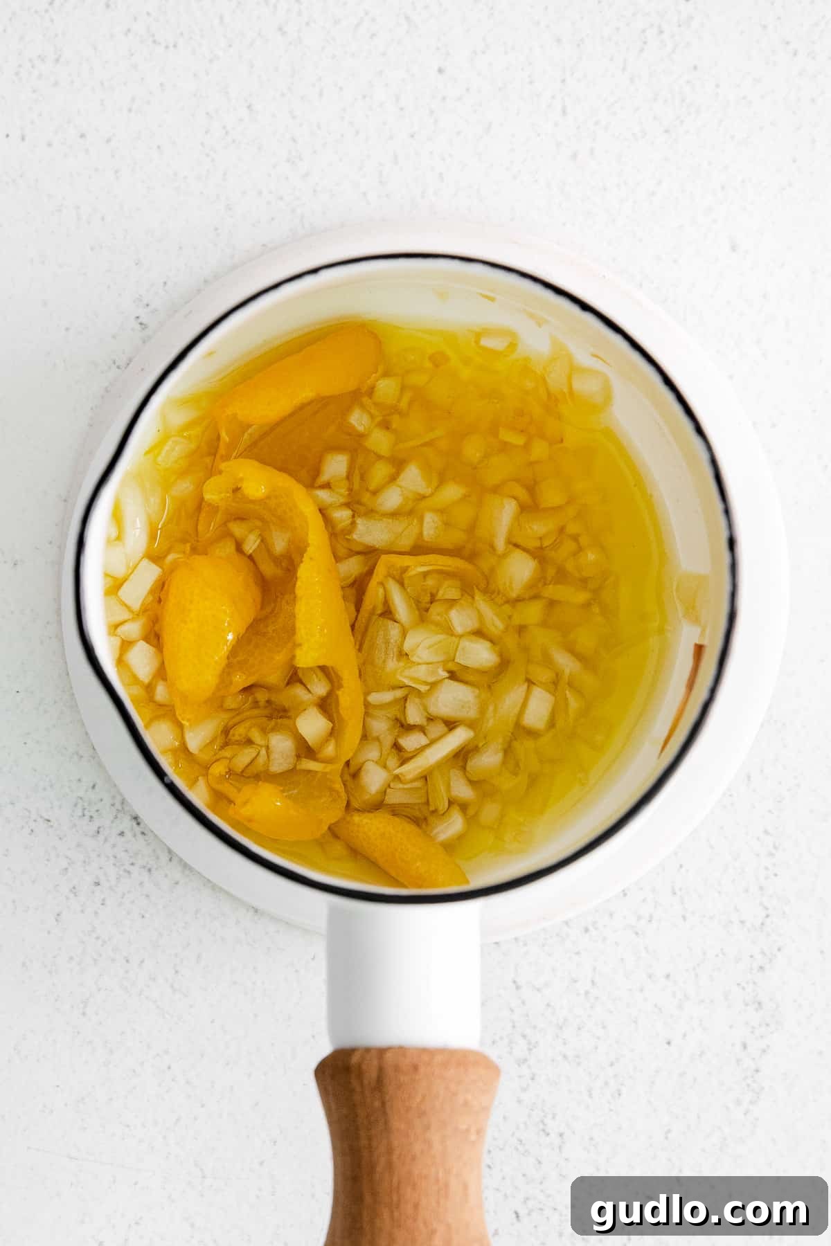 The homemade balsamic dressing being prepared in a small pot, showing the infused olive oil with garlic, a key component for the salad's flavor.
