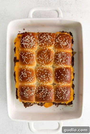 Petite Cheeseburger Perfection 6 Baked Hawaiian roll cheeseburger sliders, golden and cheesy, in a baking dish.