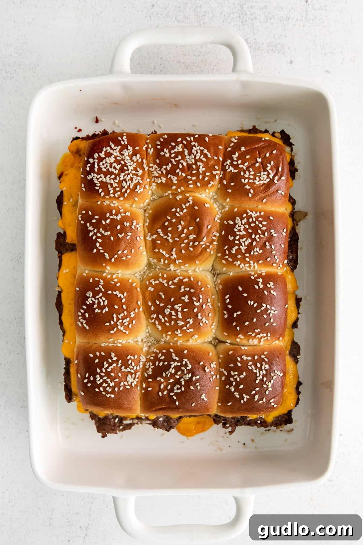 Serve Hot: Freshly Baked Cheeseburger Sliders Finished Hawaiian roll cheeseburger sliders, perfectly baked and ready for serving in a casserole dish.