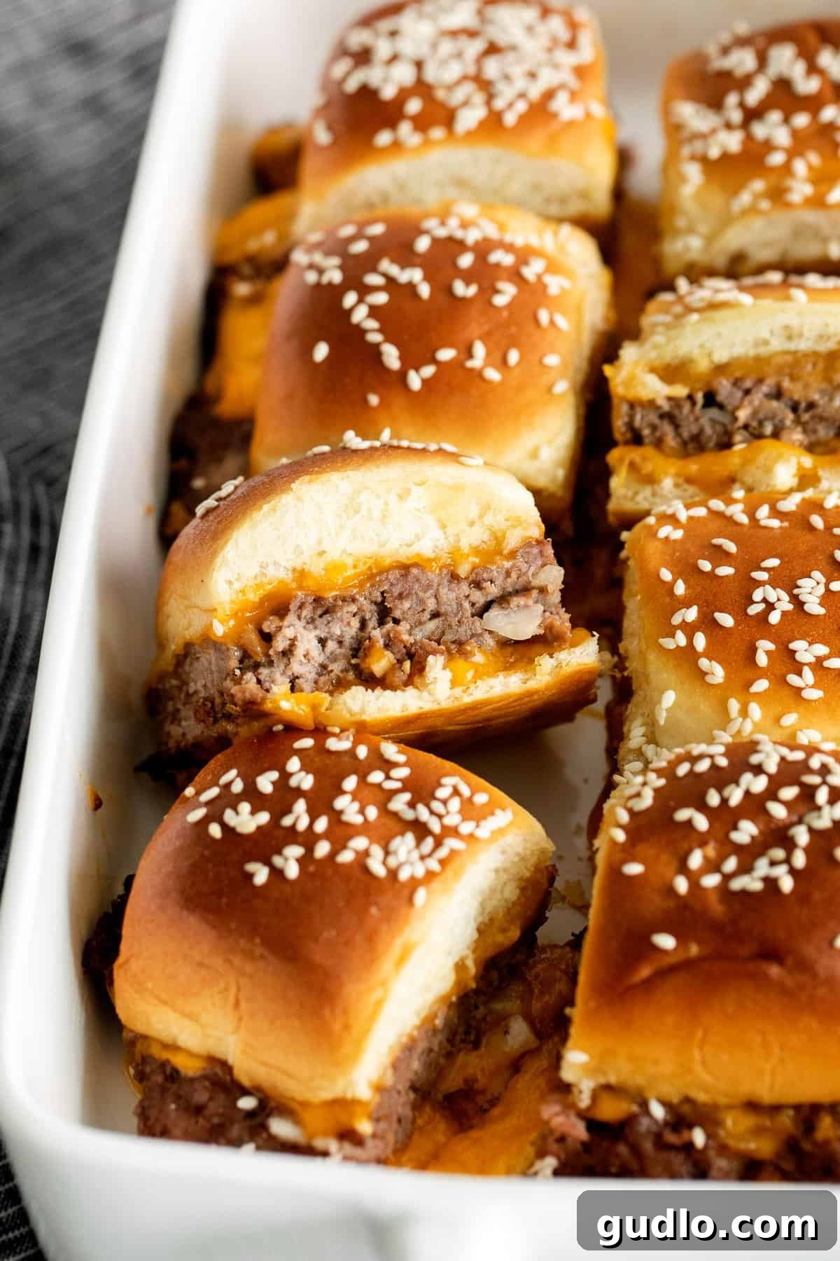 Perfectly Baked Cheeseburger Sliders Close-up of baked cheeseburger sliders in a baking dish, golden brown and cheesy.