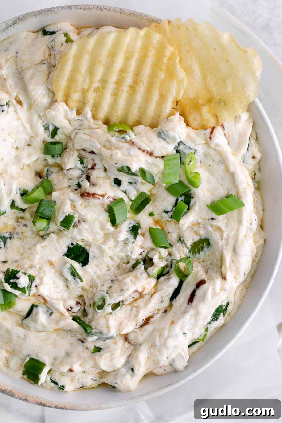 Toasted Green Onion Spread 12 A beautifully presented bowl of Sizzling Scallion Dip surrounded by crispy potato chips, ready for a party.