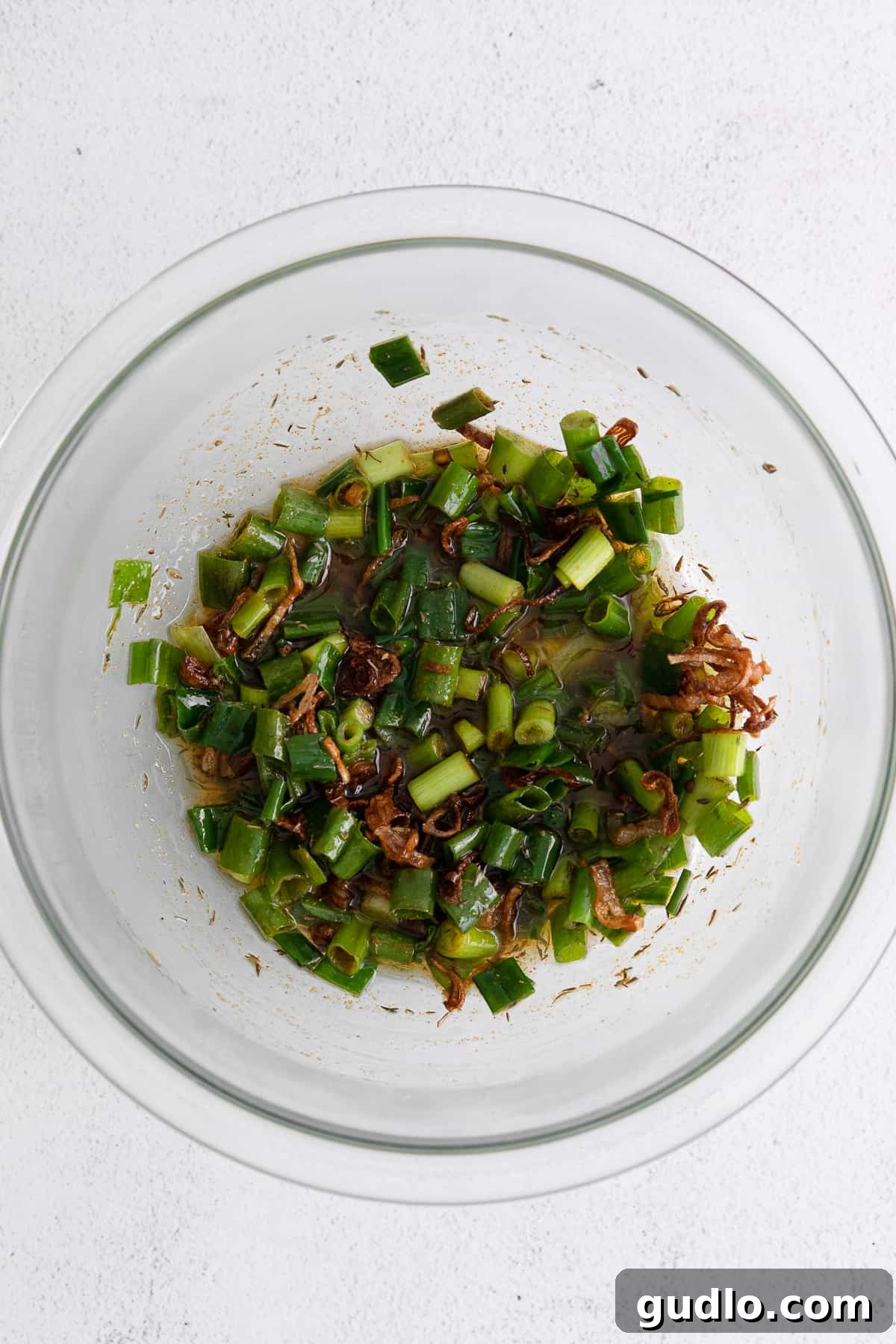 Toasted Green Onion Spread 5 A bowl filled with freshly fried, crispy shallots and green onions in their infused oil, cooling slightly before being mixed into the dip.