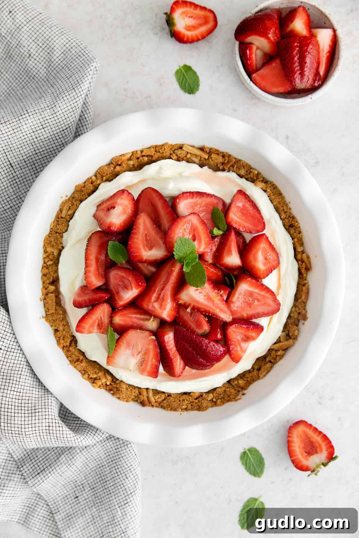 A beautifully crafted strawberry cream cheese pie in a classic pie plate, garnished with fresh mint.