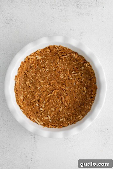 A white dish filled with granola and strawberry cream cheese pie crust on a white background.
