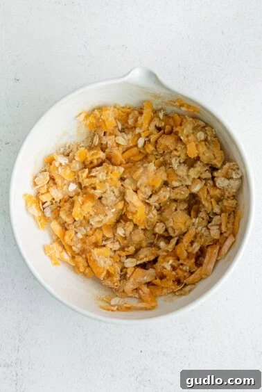 a white bowl filled with shredded cheese and granola.