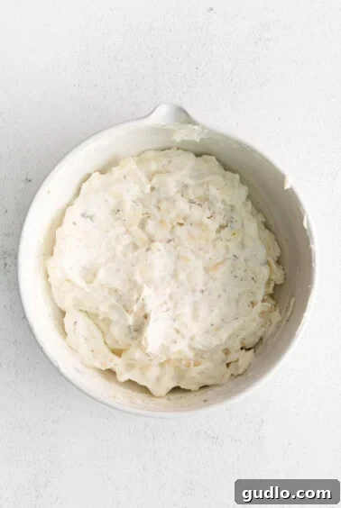 A bowl filled with creamy cheese tortellini filling, neatly prepared and ready to be used.