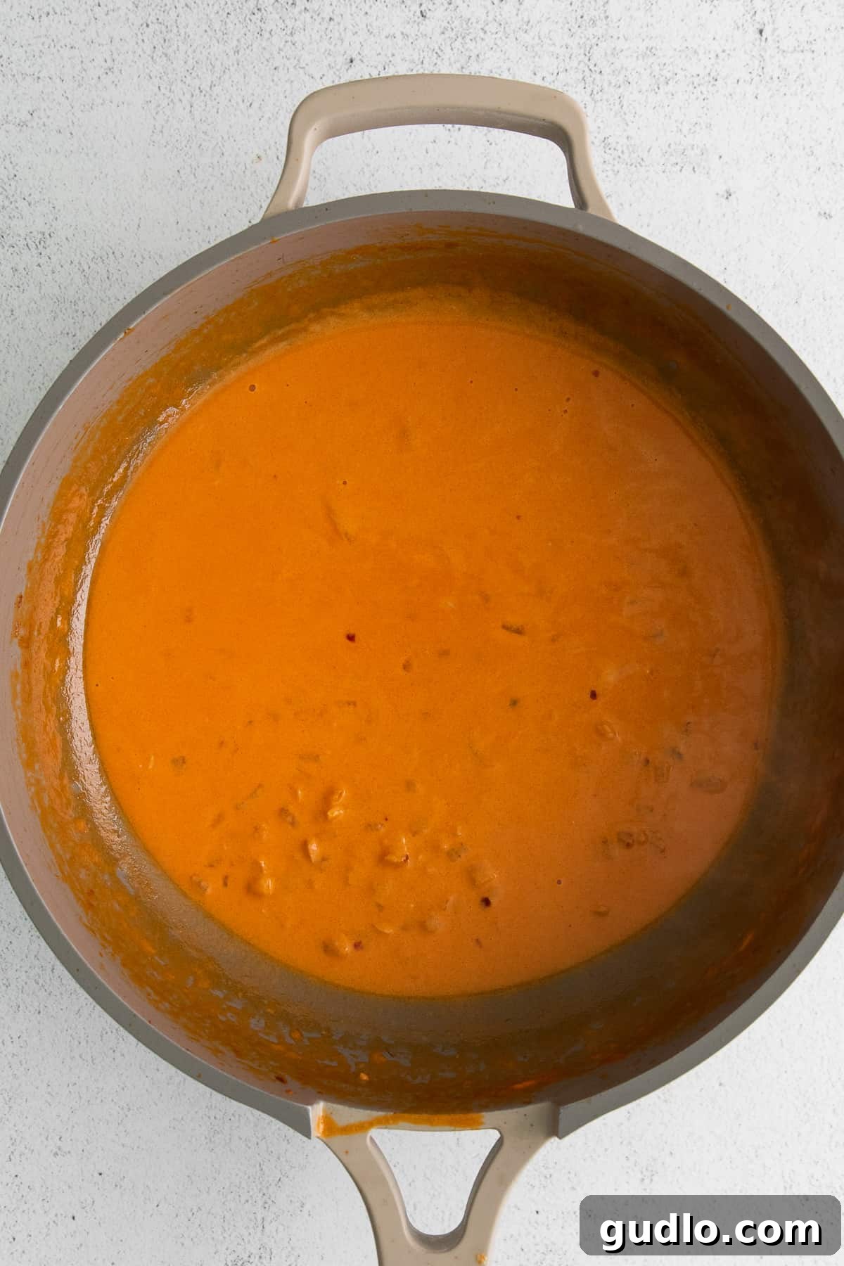 Vodka Blush Tortellini 6 A rich and creamy homemade vodka sauce simmering gently in a large pan, its inviting aroma filling the kitchen, ready to be combined with pasta.