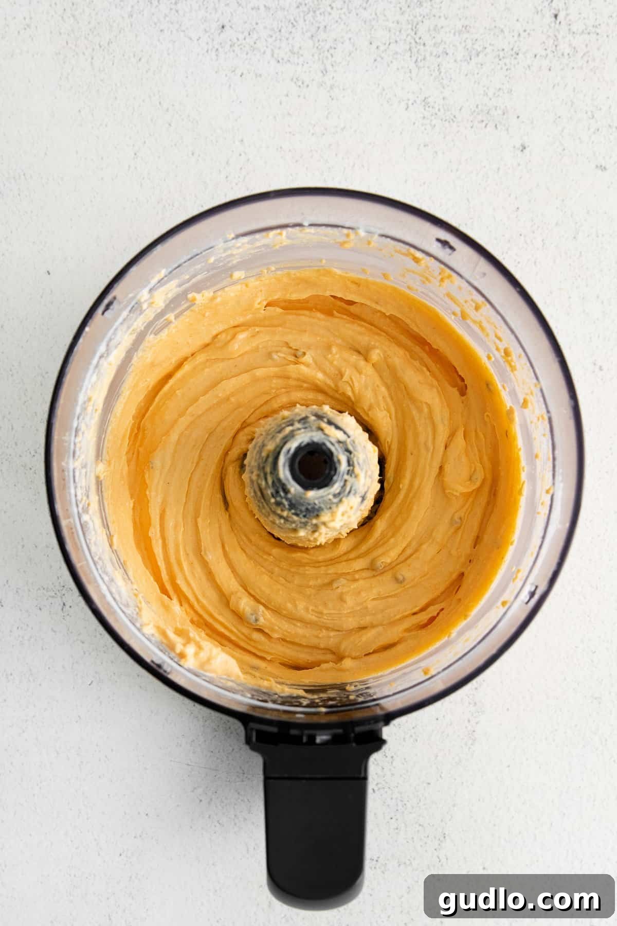 Blending for a Silky Homemade Cheese Spread A food processor blending the cheese, half and half, and seasonings into a perfectly smooth and creamy homemade cheese spread.