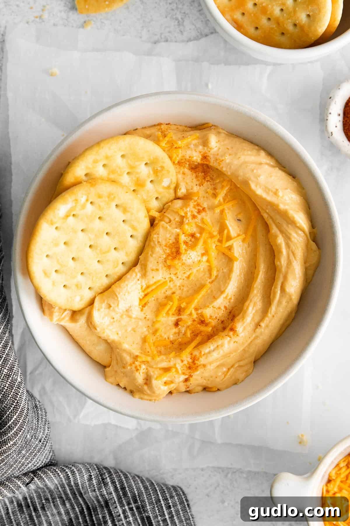 Ready to Enjoy: Homemade Cheese Spread with Crackers A beautiful bowl of homemade cheese spread served with a variety of golden crackers, ready for dipping and enjoying.