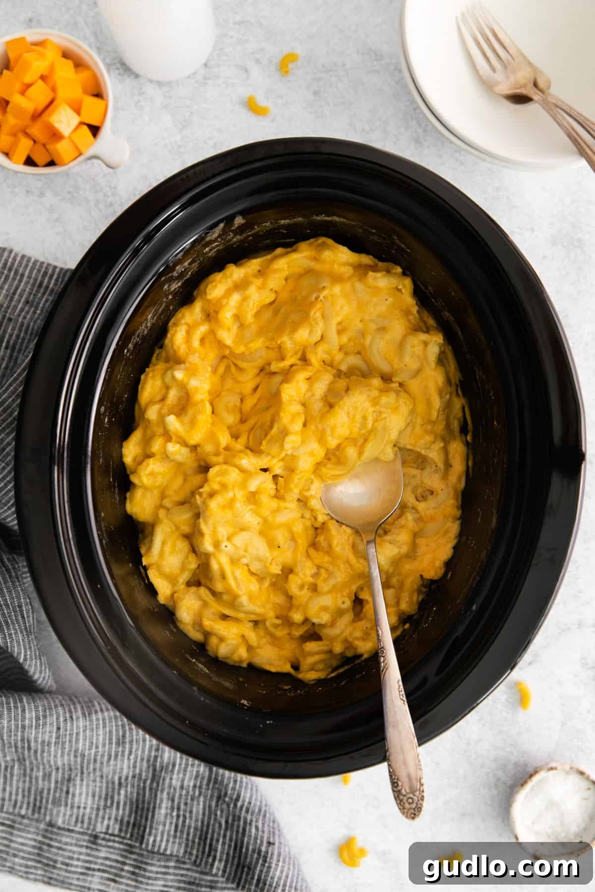 Cooked Crockpot Mac and Cheese A close-up of bubbling, golden mac and cheese in a crockpot, freshly cooked and ready for a final stir.