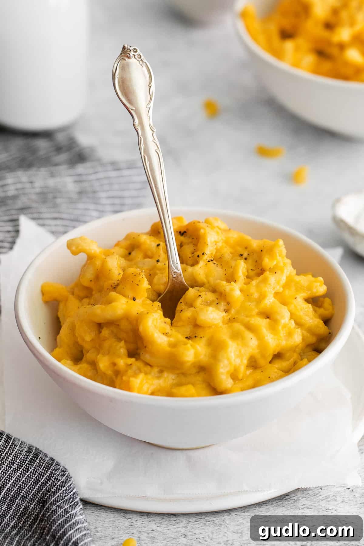 Crockpot Mac and Cheese Ready to Serve A close-up of a serving of creamy, golden crockpot mac and cheese in a rustic bowl, garnished with fresh parsley.