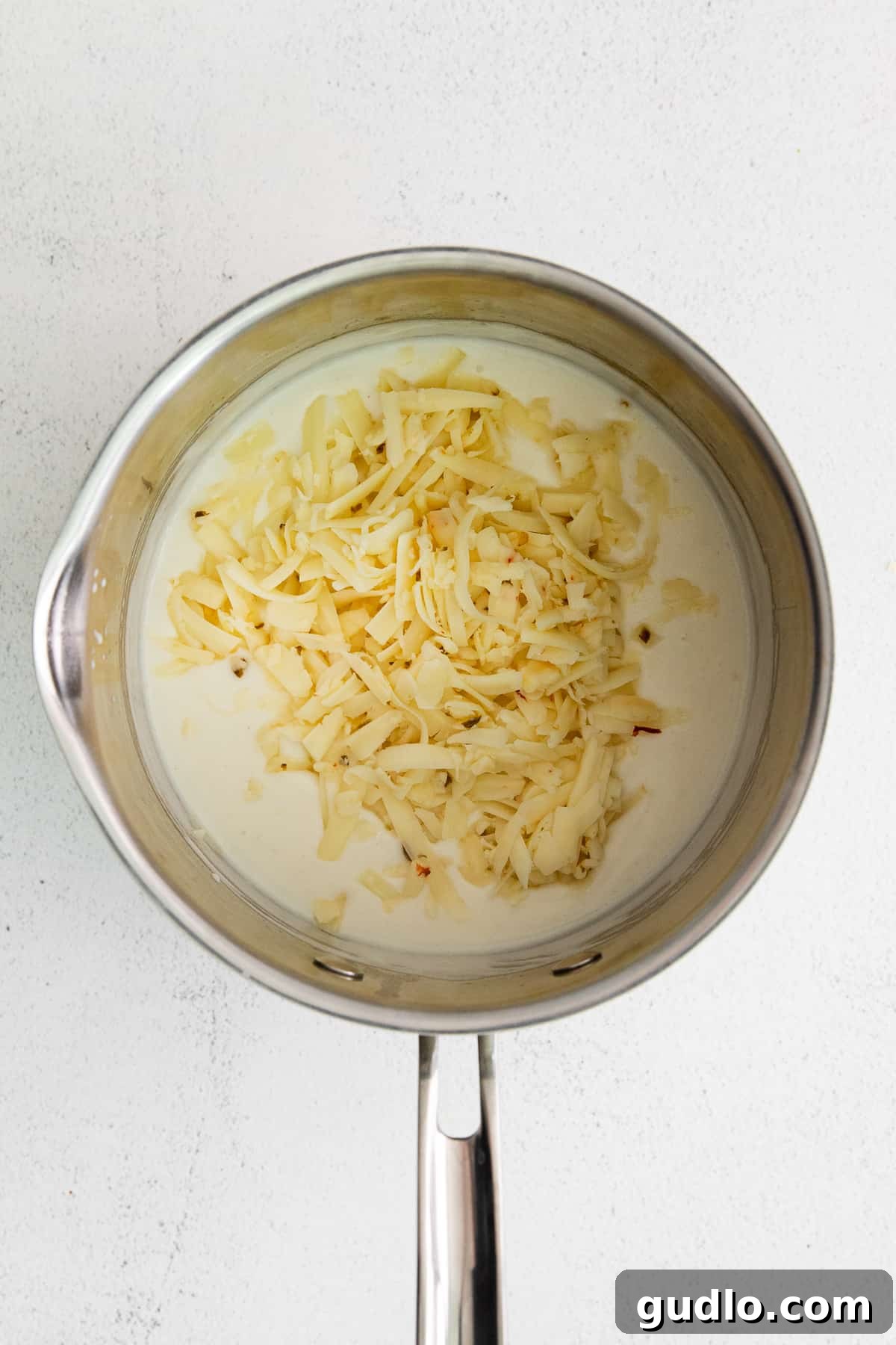 A smooth, light-colored roux being created in a saucepan, signaling the start of a rich cheese sauce.