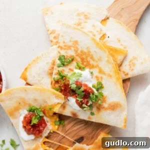 Crispy golden cheese quesadillas arranged on a rustic wooden cutting board.