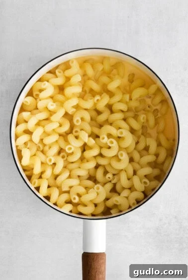 macaroni in a pan with a wooden spoon.