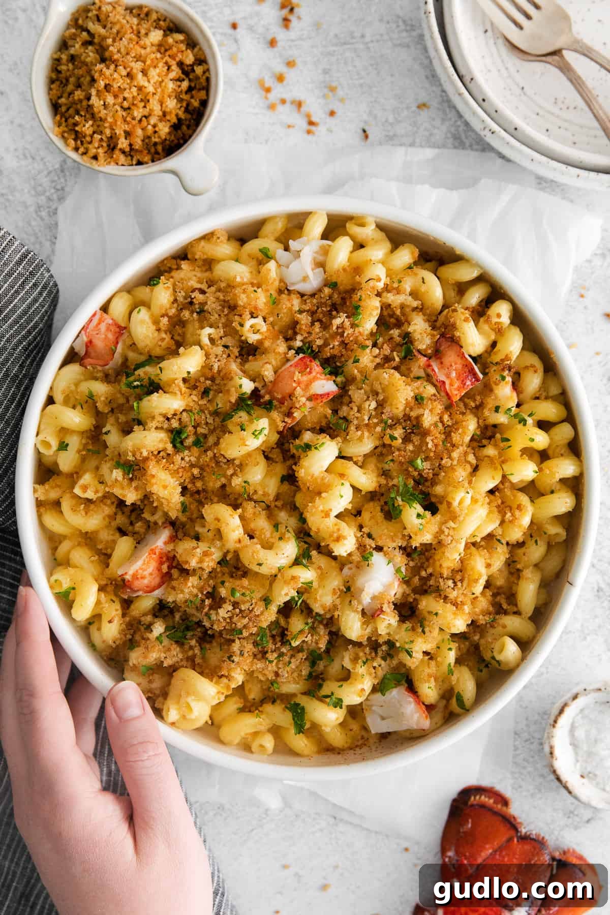 Decadent Lobster Macaroni 6 A generous serving of lobster mac and cheese in a rustic white bowl, ready to be enjoyed.