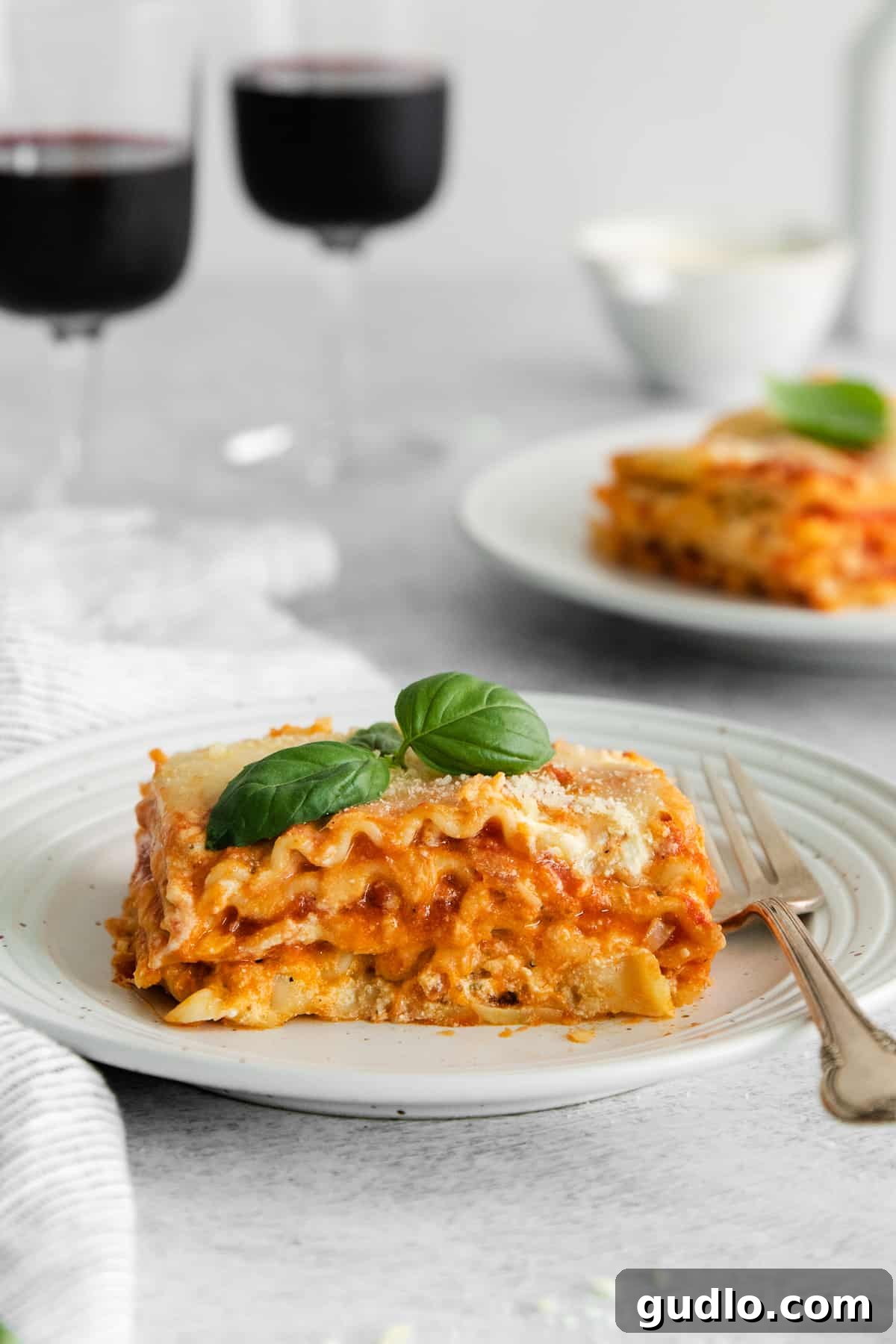 Deliciously layered cheese lasagna on a plate. A generous slice of classic cheese lasagna, perfectly layered and golden brown, resting on a white plate, ready to be enjoyed.
