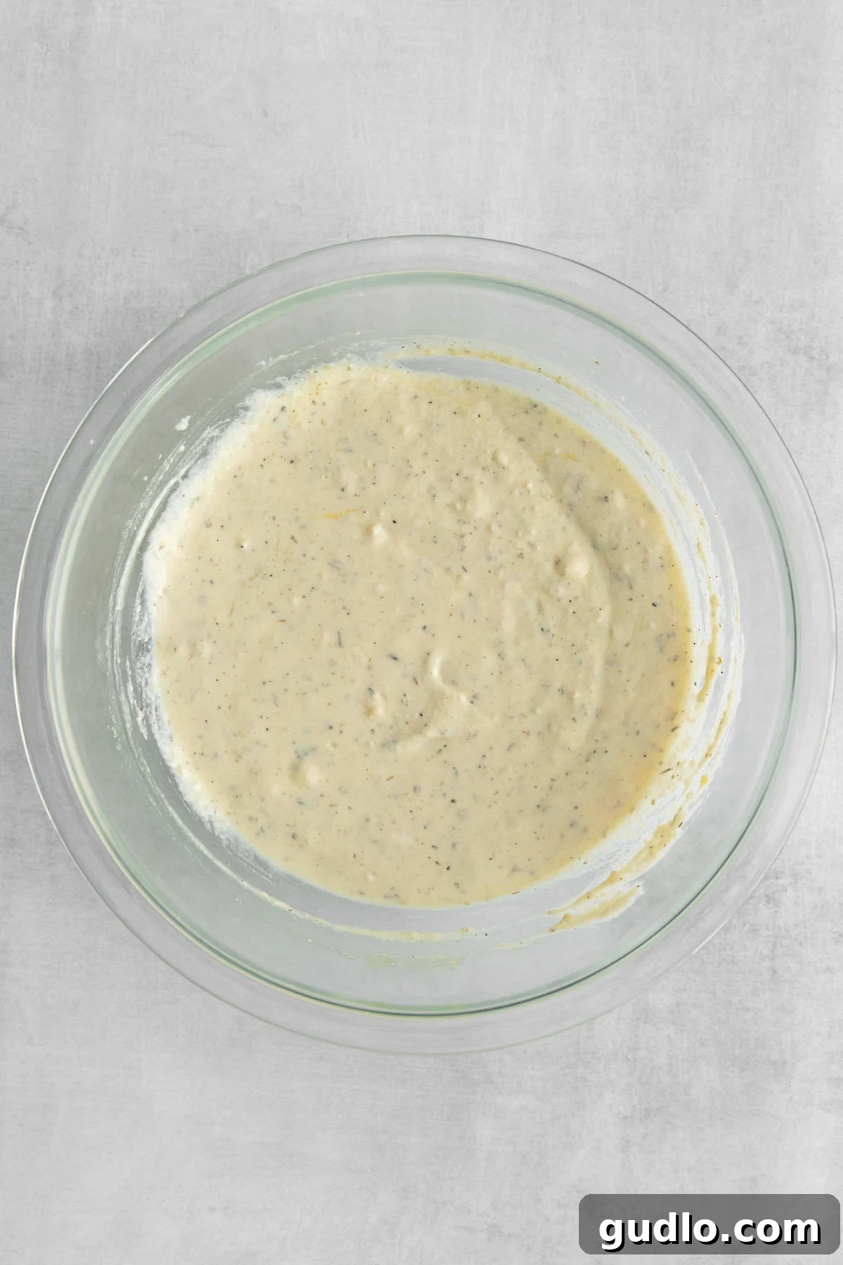 Ricotta cheese mixture in a bowl. A medium bowl filled with the creamy, expertly blended ricotta cheese mixture, ready for layering in the lasagna.