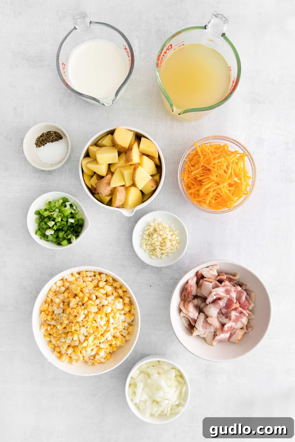 Fresh Ingredients for Homemade Corn Chowder Bowls filled with the fresh ingredients for making corn chowder, including corn kernels, diced potatoes, onions, and bacon.