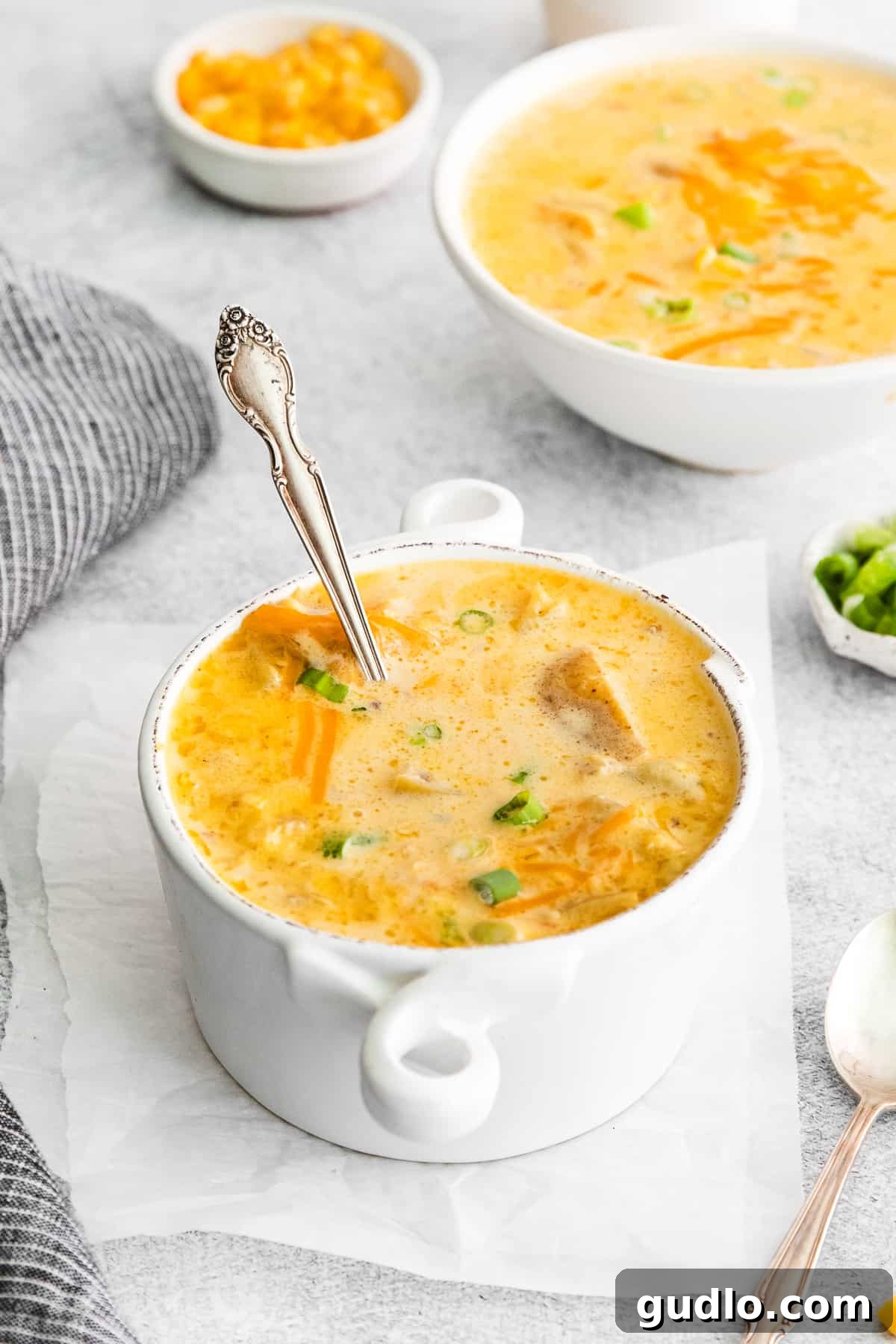 Hearty Corn Chowder Ready to Serve A comforting bowl of cheesy corn chowder with a spoon, ready to be enjoyed.