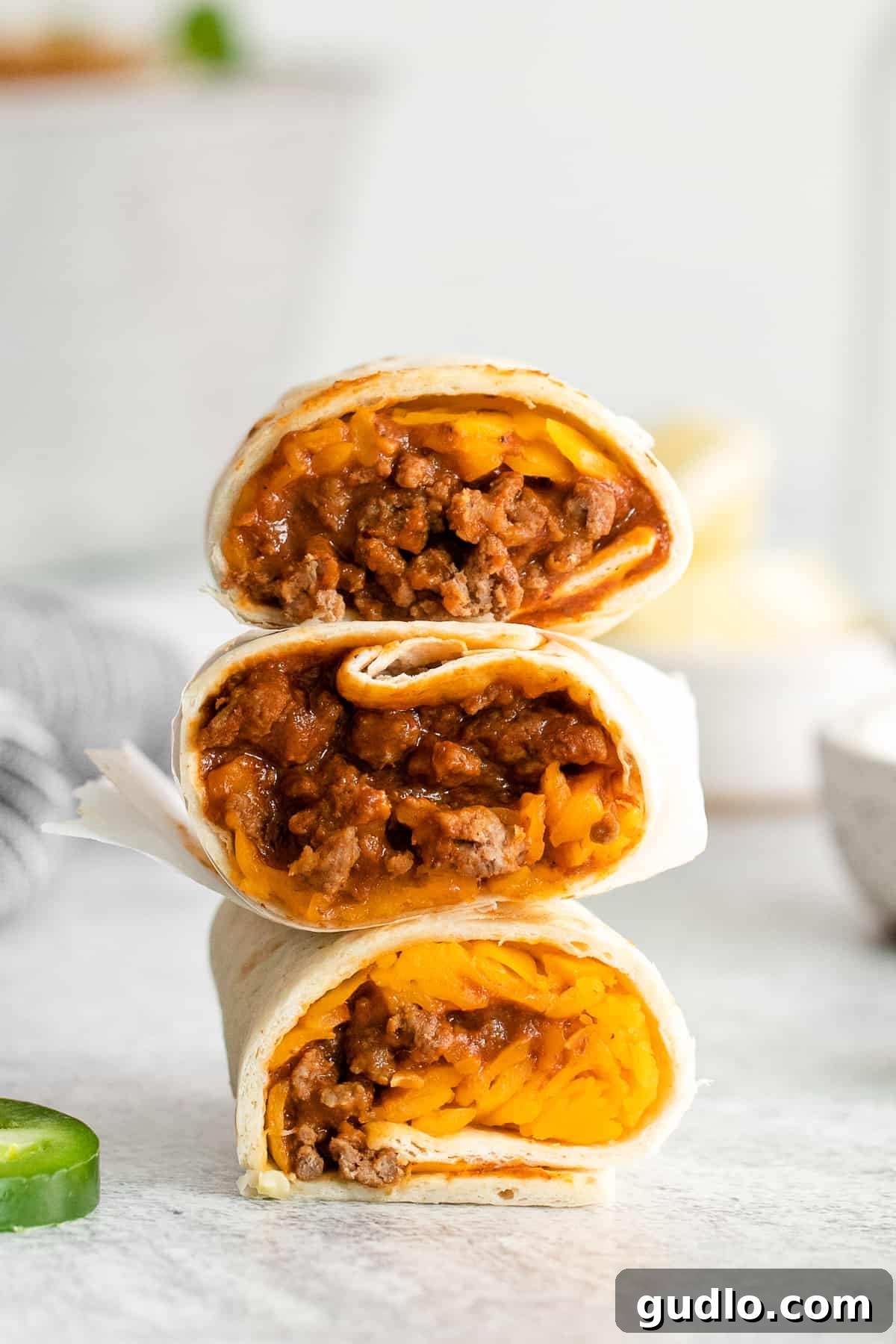 A stack of perfectly rolled chili cheese burritos, ready to be enjoyed.