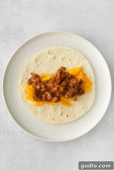 Beef and cheese filling placed on a tortilla.