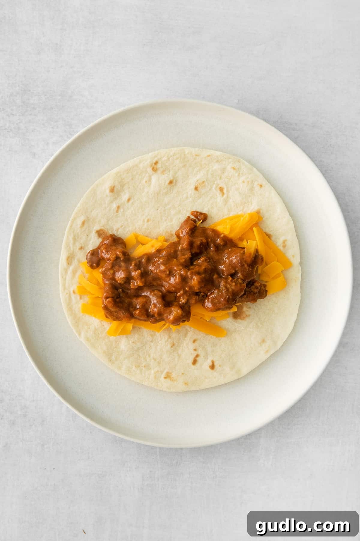 The savory beef and cheese filling spread on a tortilla, ready for rolling.