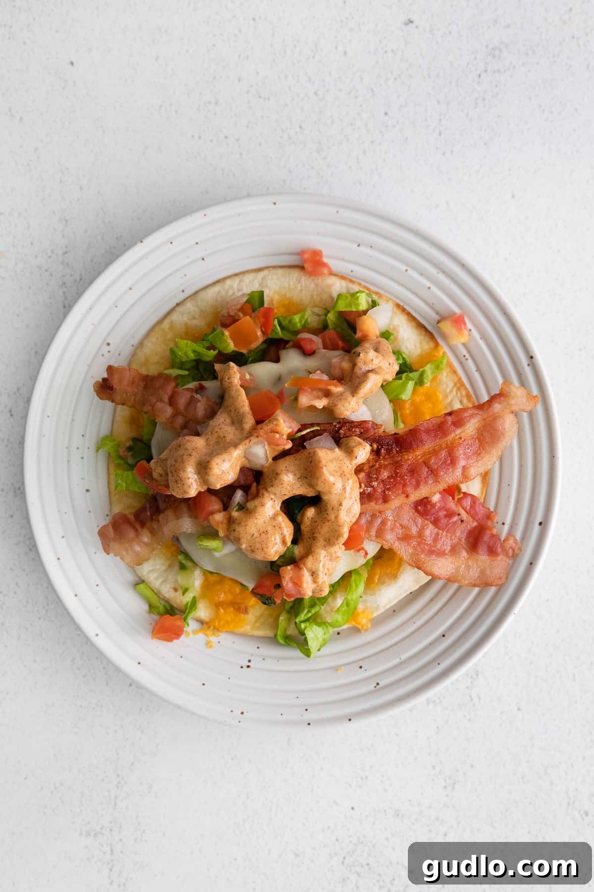 A beautifully arranged plate showcasing all the fixings for a copycat Applebee's quesadilla burger, inviting guests to build their own.