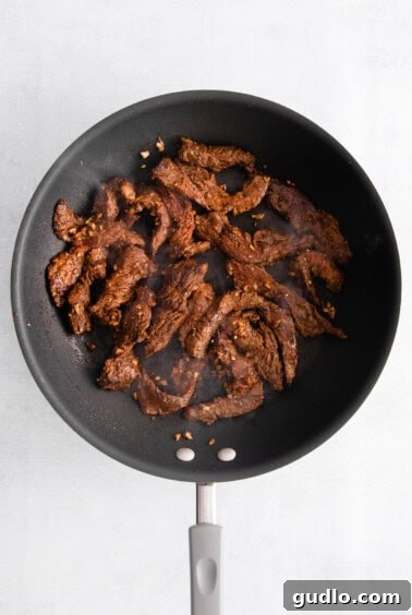 Sizzling Steak and Cheese Tortillas 7 cooked steak in pan.